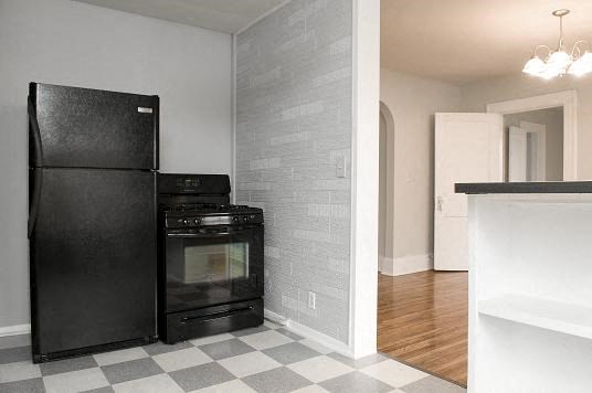 a kitchen with a black refrigerator and an oven