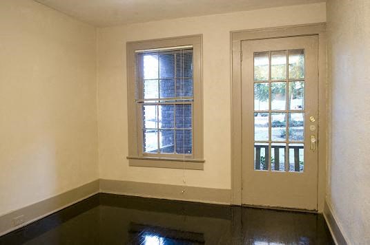 an empty room with a door and a window