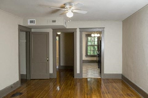 an empty living room with a ceiling fan