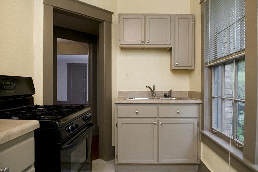a kitchen with a stove and sink and a window
