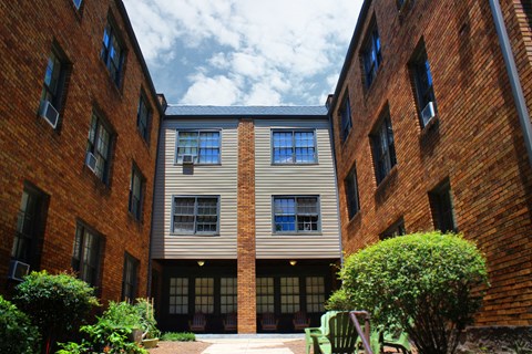 the exterior of a building with a courtyard and benches