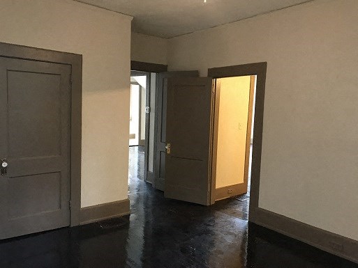 an empty room with two doors and a door open