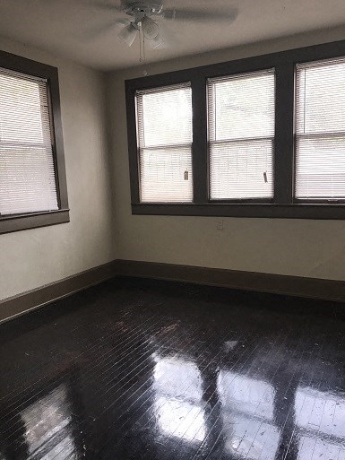 an empty room with three windows and a wooden floor