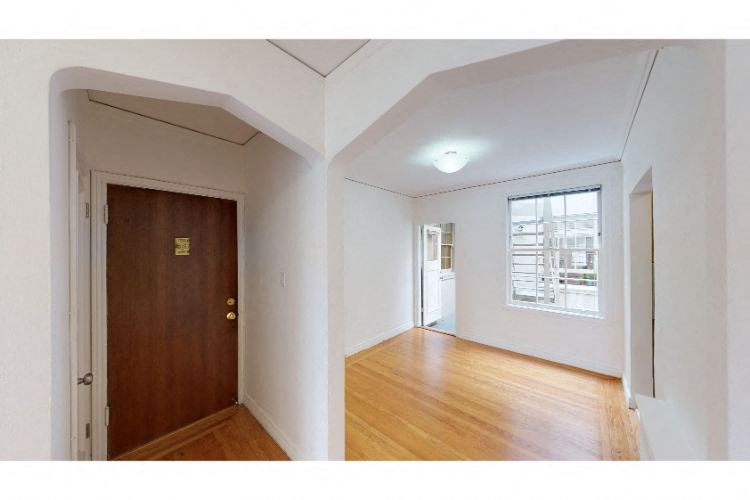 an empty room with a wooden floor and a door