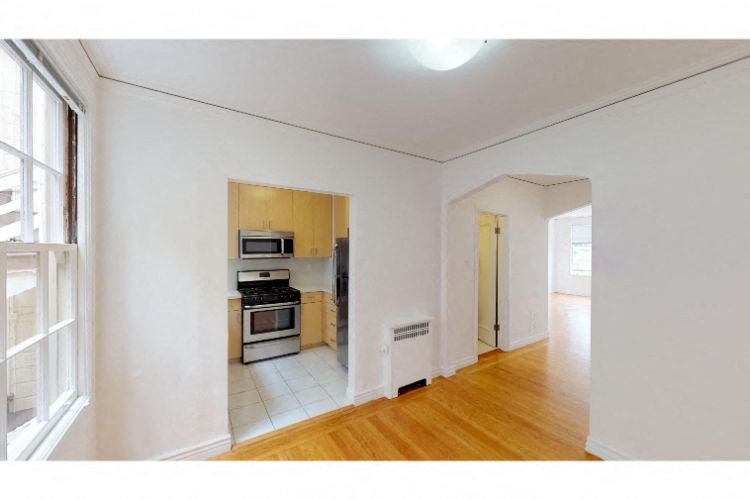a living room and a kitchen with a wood floor