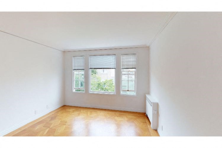 an empty room with three windows and a wooden floor