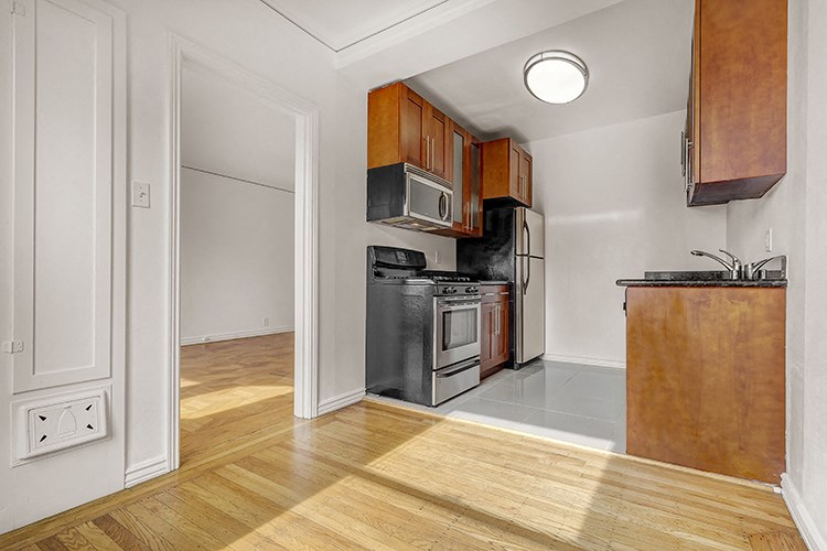 a renovated kitchen with wood flooring and a stove and refrigerator