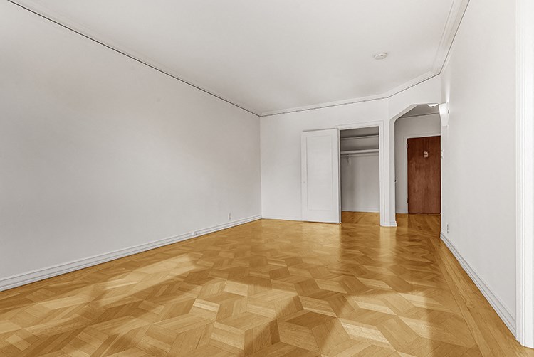 a living room with a wooden floor and white walls