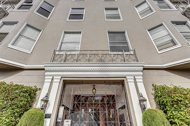 the front of a building with a door and a balcony