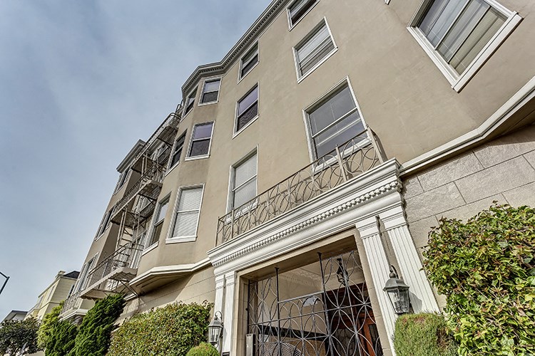 an exterior view of a building with a balcony and a door