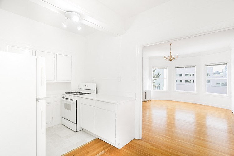 an empty kitchen with a stove and a refrigerator