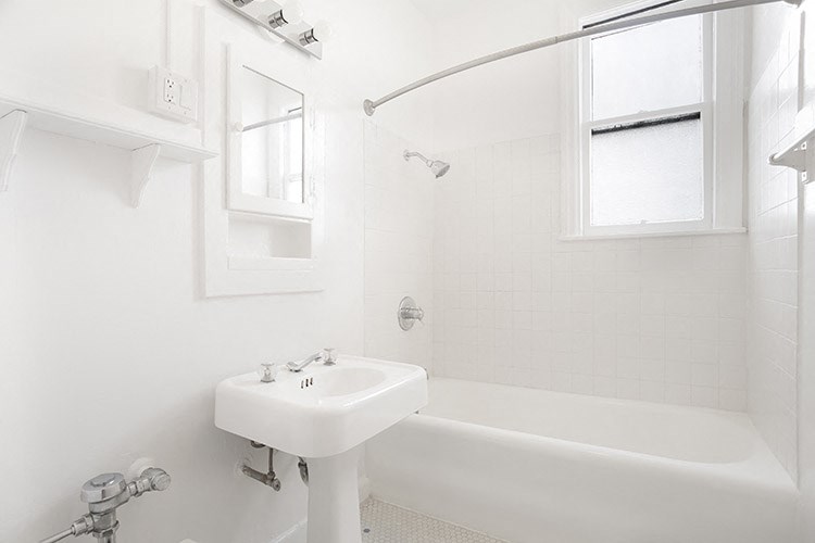 a white bathroom with a sink and a bath tub