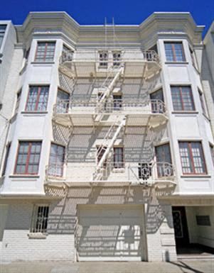 a tall white building with a fire escape