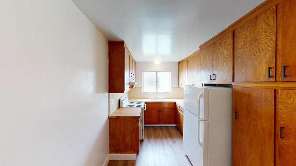 a kitchen with wooden cabinets and a white refrigerator