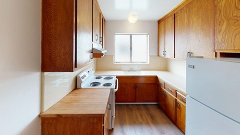 a kitchen with wooden cabinets and a stove and a refrigerator