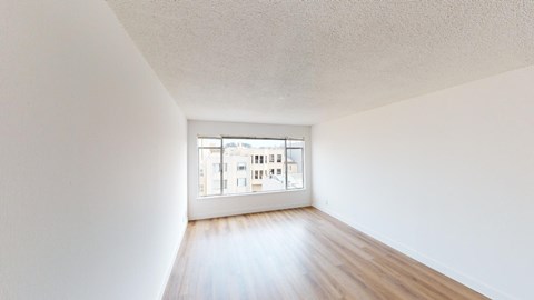 an empty room with wood floors and a window