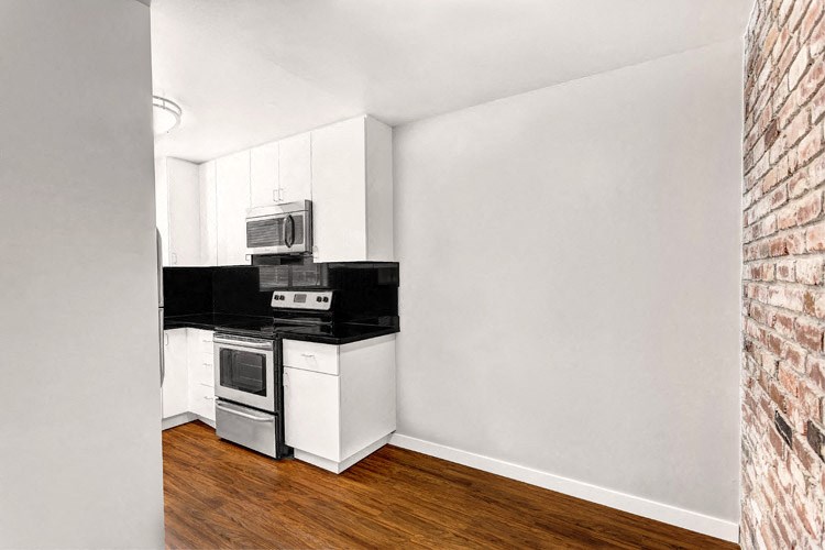 an empty kitchen with a stove and a microwave