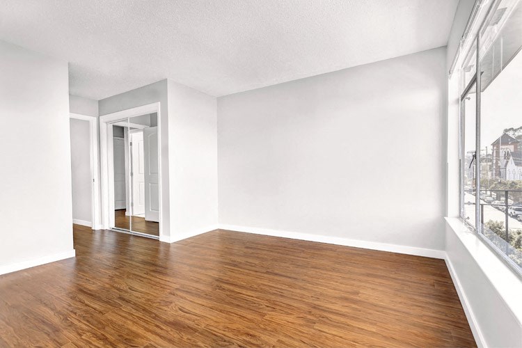 an empty living room with white walls and wood floors