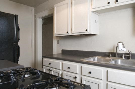 a kitchen with a stove and a sink and a refrigerator