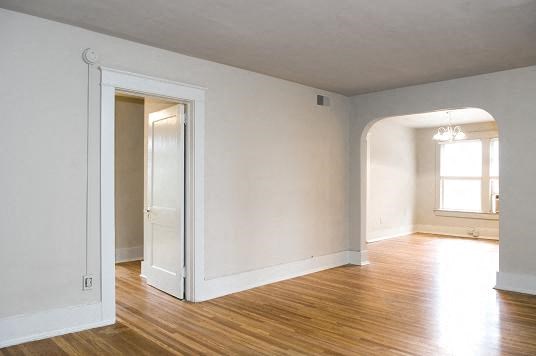 an empty living room with white walls and a door