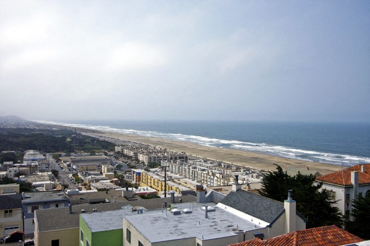 a view of the beach from the top of a house
