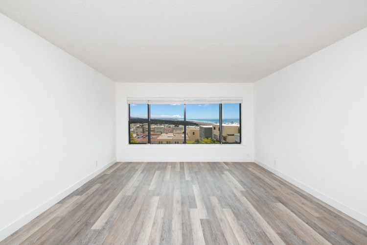 an empty room with wood floors and a window