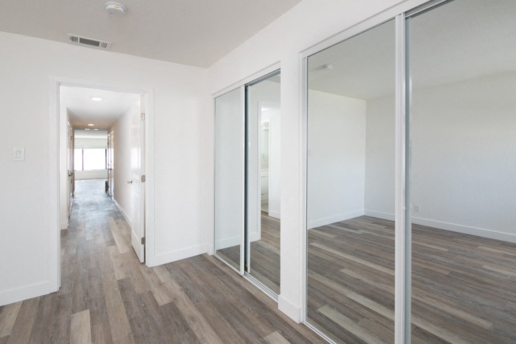 an empty room with white walls and mirrored sliding glass doors