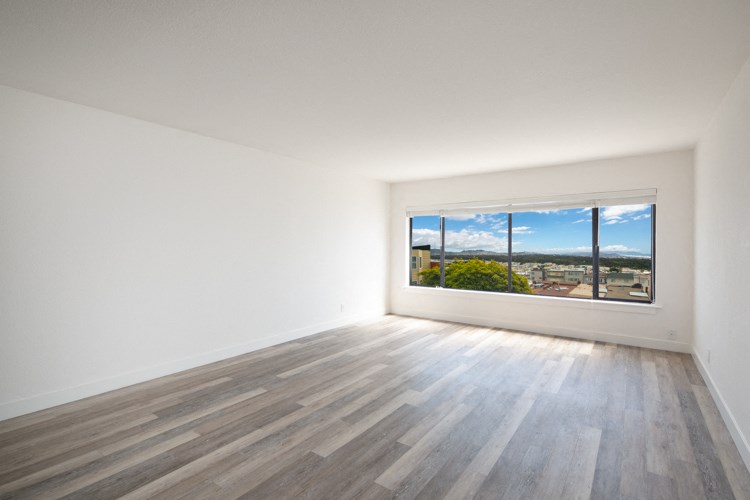 an empty room with wood floors and a window