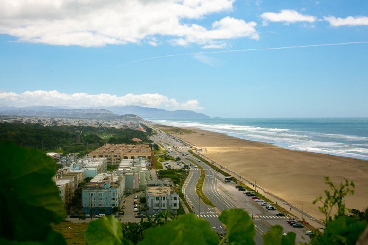 a view of the beach from the top of a hill
