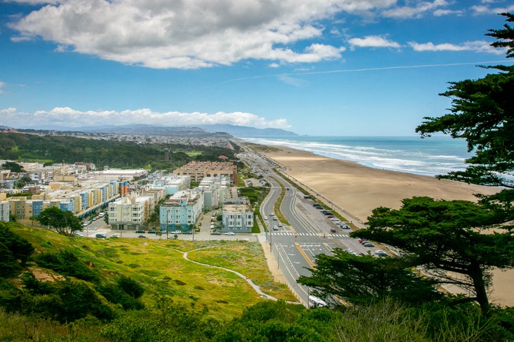 a view of the beach from the top of a hill