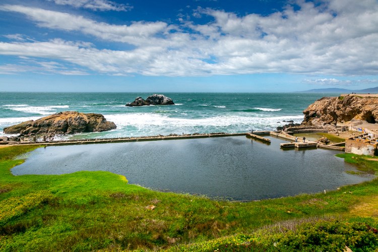 a small pool with the ocean in the background