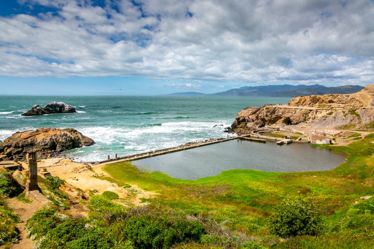 a small pool of water next to the ocean