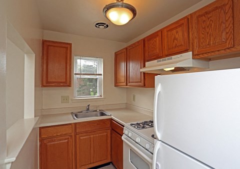 A kitchen with wooden cabinets and a white refrigerator.