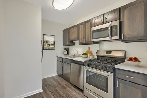 A kitchen with a stove top oven and microwave above it.