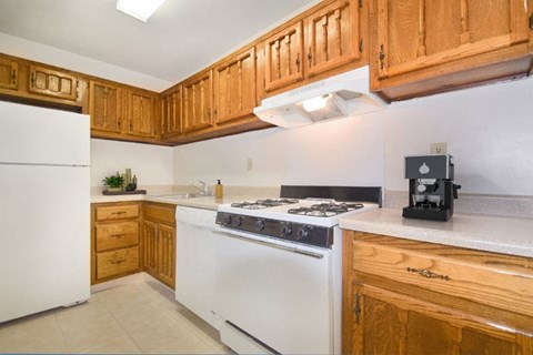 a kitchen with white appliances and wooden cabinets