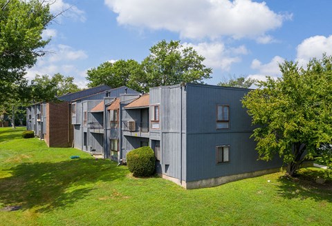 A grey building with a green lawn in front.
