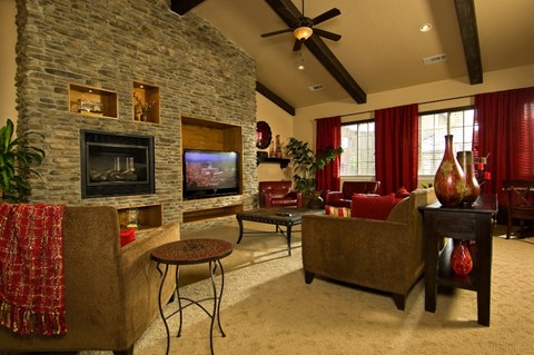 a living room with a large stone fireplace and a tv