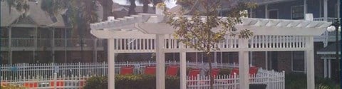 a white gazebo with benches in front of a house
