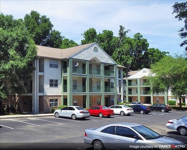 a parking lot with cars in front of an apartment building
