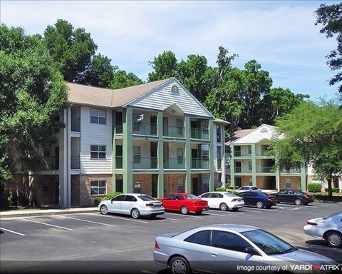 a parking lot with cars in front of an apartment building