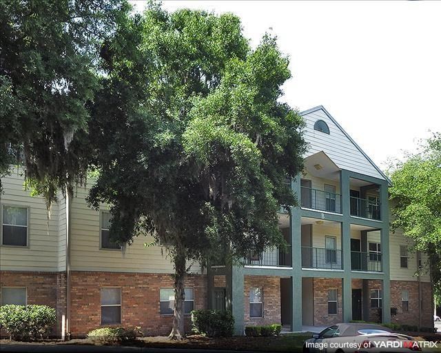 a brick apartment building with trees in front of it