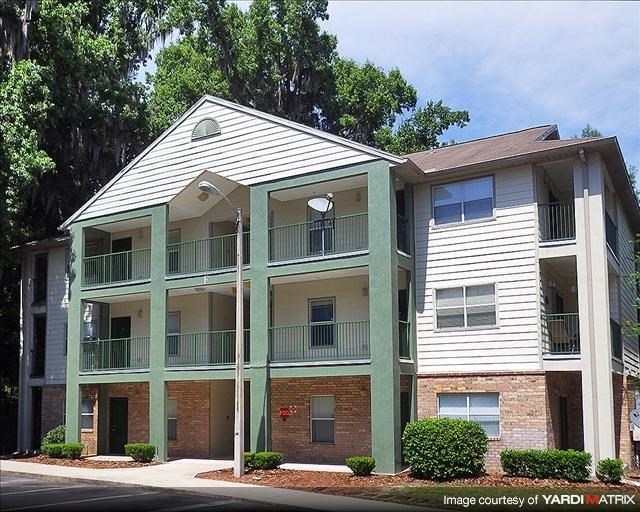 a white apartment building with green pillars