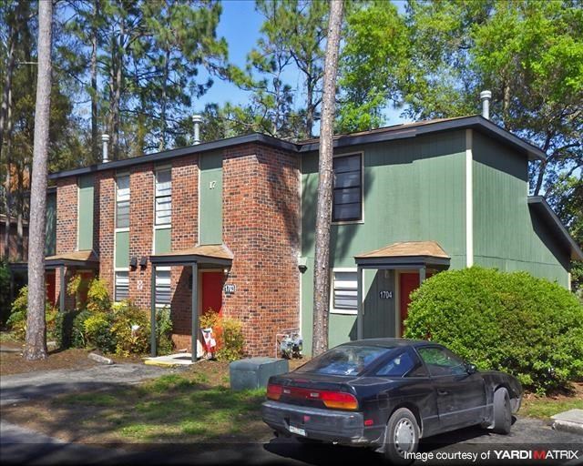 a black car parked in front of a green house