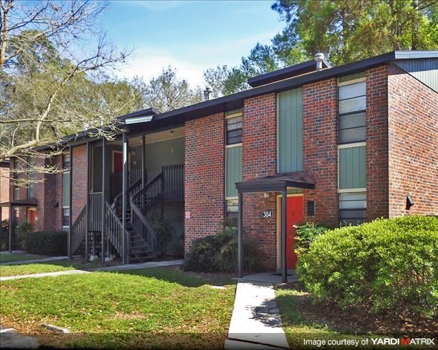 a brick building with a red door and stairs