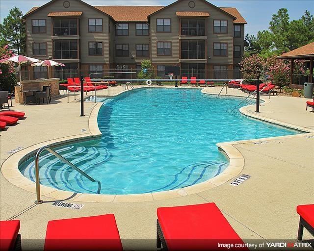a large swimming pool with red chairs around it