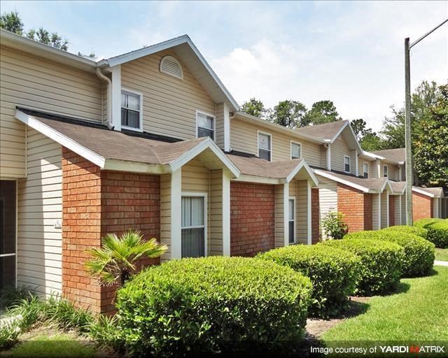 a row of houses with bushes in front of them