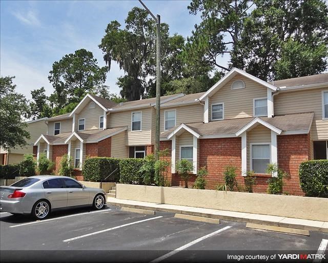 a car parked in a parking lot in front of an apartment building