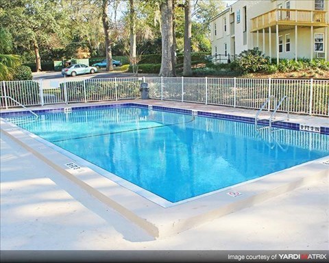 a large blue swimming pool next to a fence