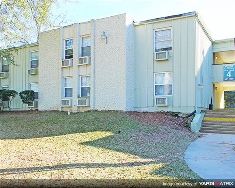 an apartment building with a yard in front of it