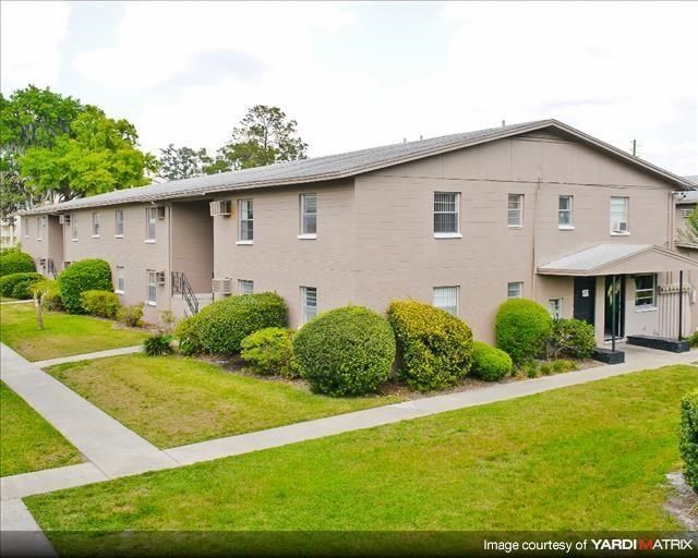 a white house with a yard and bushes